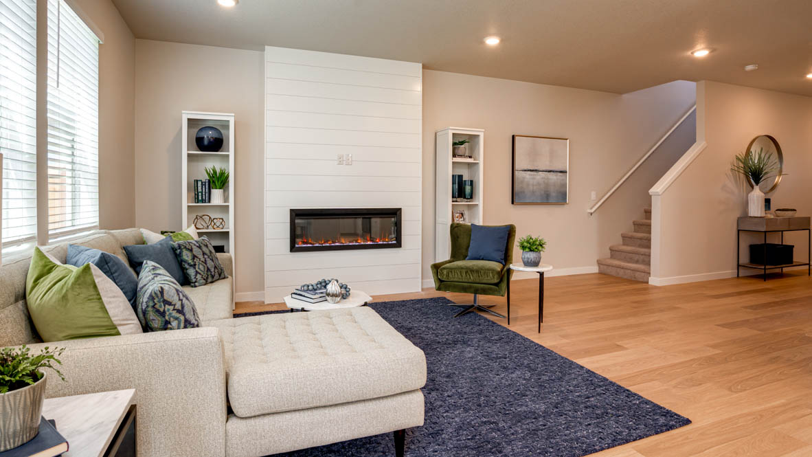Davis Estates great room with fireplace, laminate flooring, and the stairs in the background