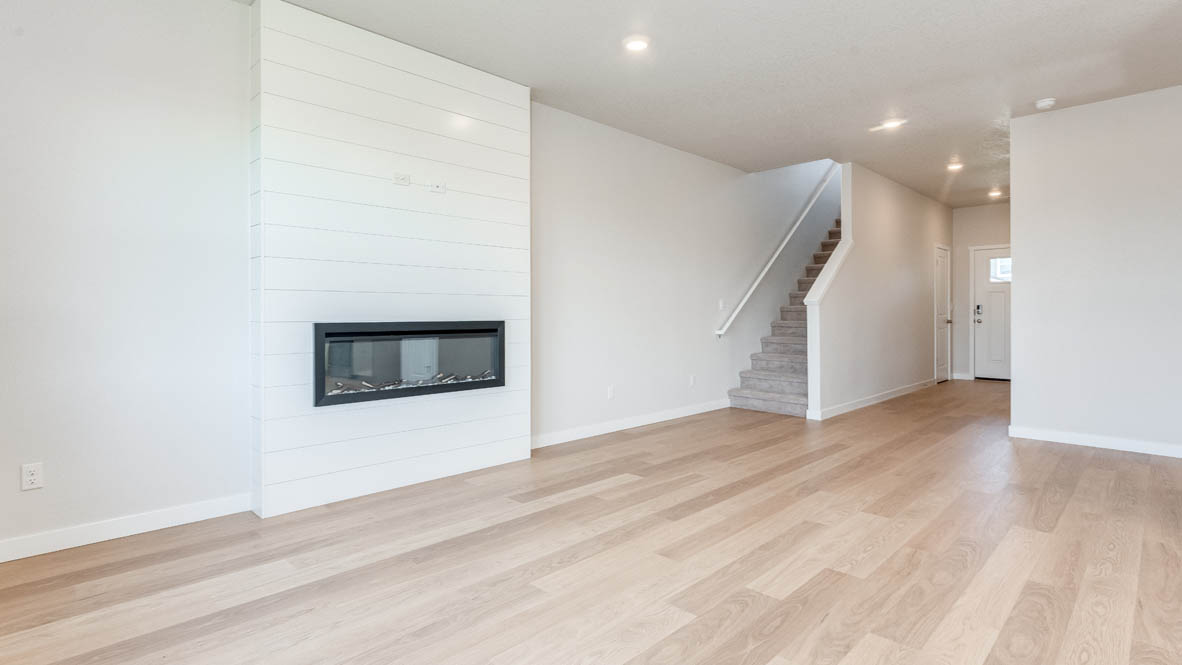 Davis Estates great room with fireplace, laminate flooring, and the stairs in the background