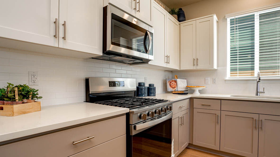 Davis Estates kitchen with laminate flooring, stainless steel appliances, cabinets, window, solid surface countertops