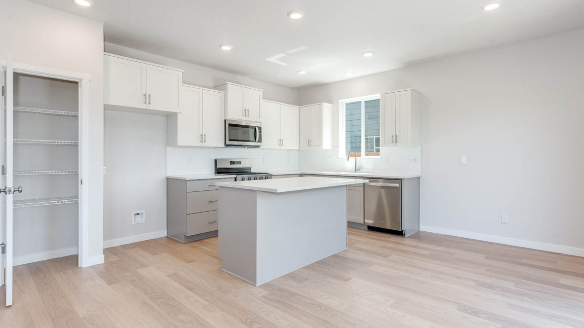 Davis Estates kitchen with laminate flooring, stainless steel appliances, cabinets, window, solid surface countertops