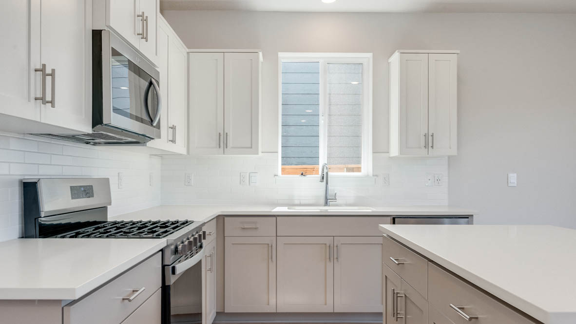 Davis Estates kitchen with laminate flooring, stainless steel appliances, cabinets, window, solid surface countertops