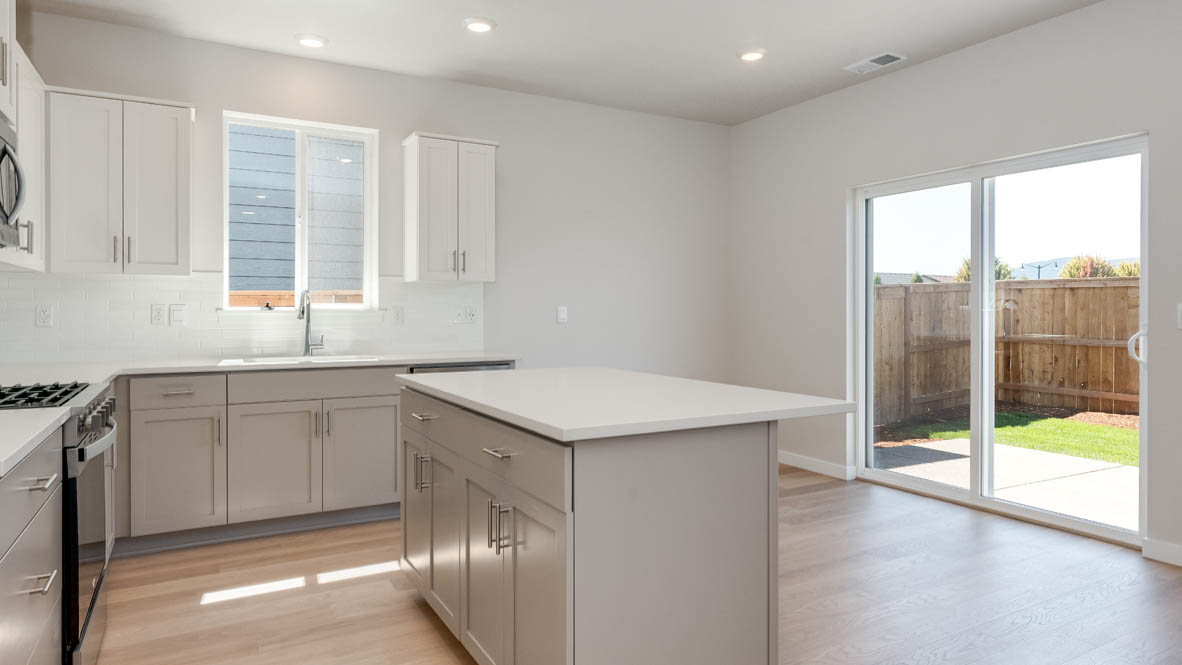 Davis Estates kitchen with laminate flooring, stainless steel appliances, cabinets, window, solid surface countertops