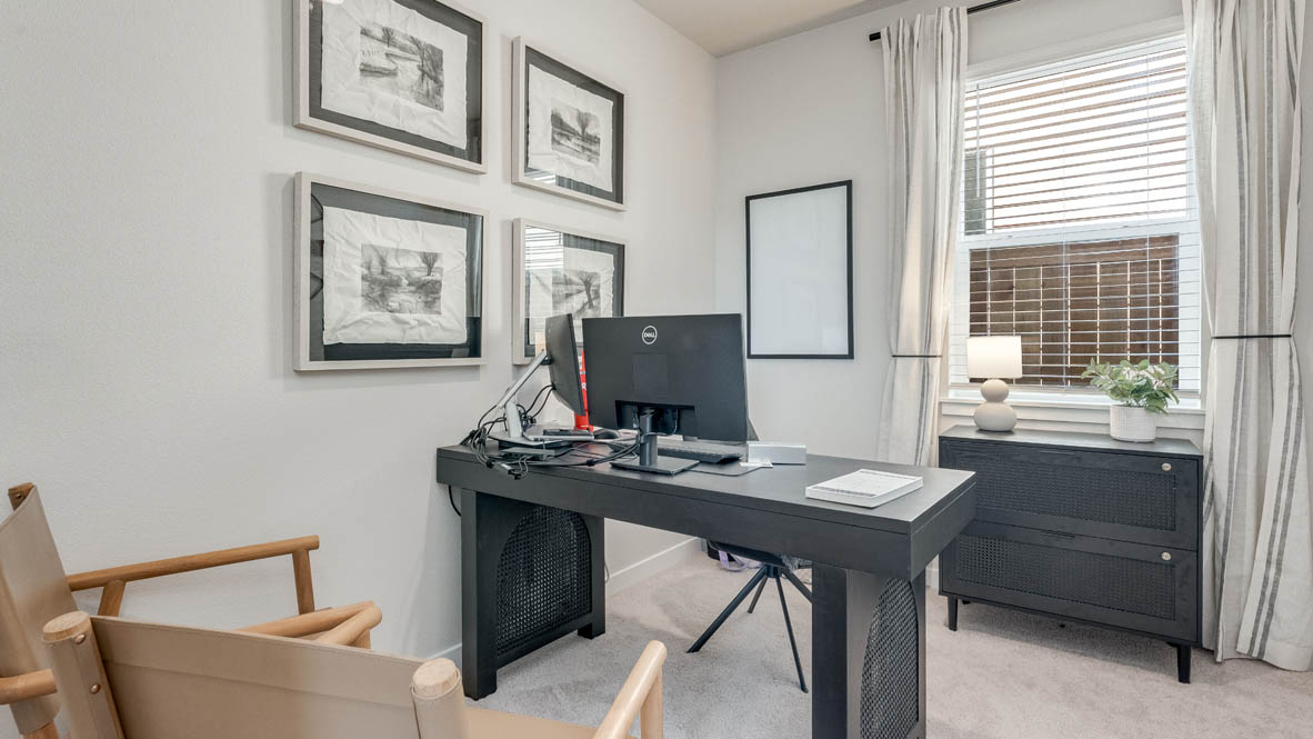 Davis Estates office with dark wood desk, paintings, chair, window with curtains