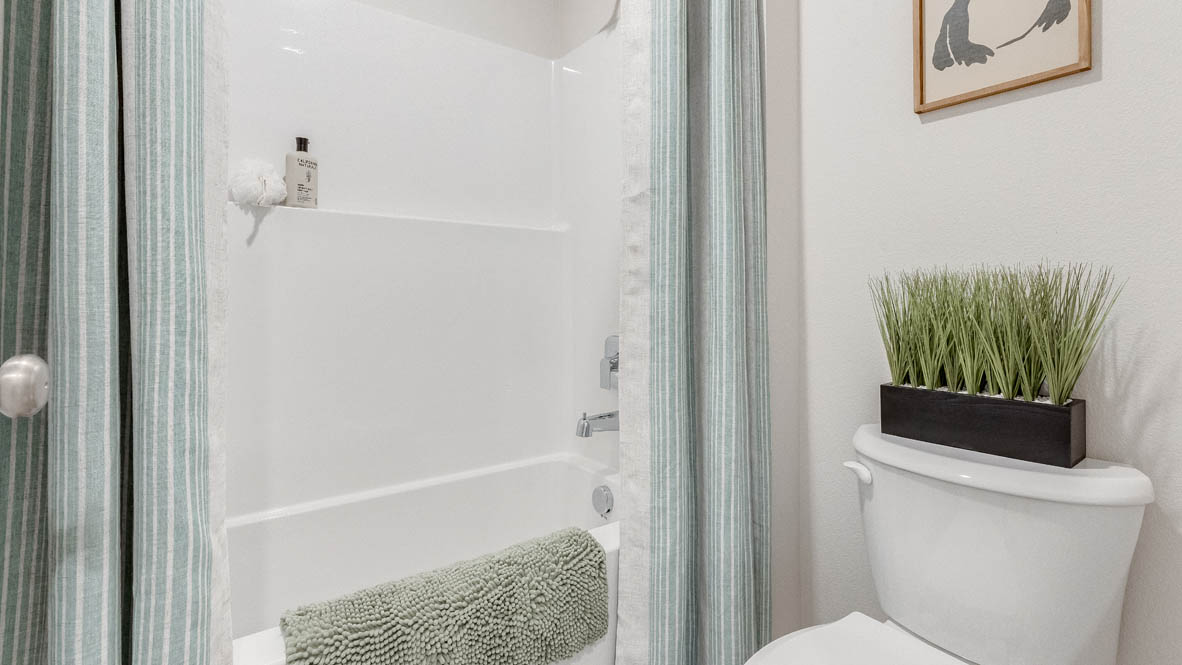 Davis Estates secondary bathroom with toilet, shower tub, white toilet with a plantDavis Estates secondary bathroom with toilet, shower tub, white toilet with a plant