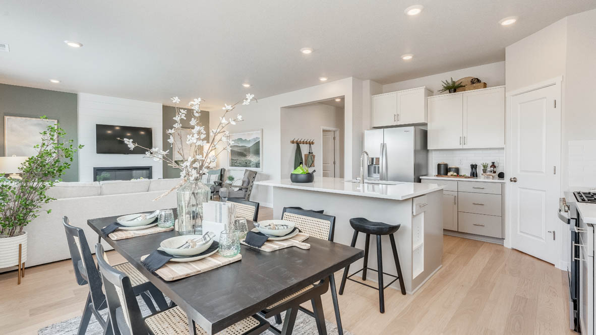 Davis Estates Dining room and Kitchen with a table with four chairs, solid quartz countertops, in-island sink with a breakfast bar, stainless steel appliances, shaker style cabinets, pantry