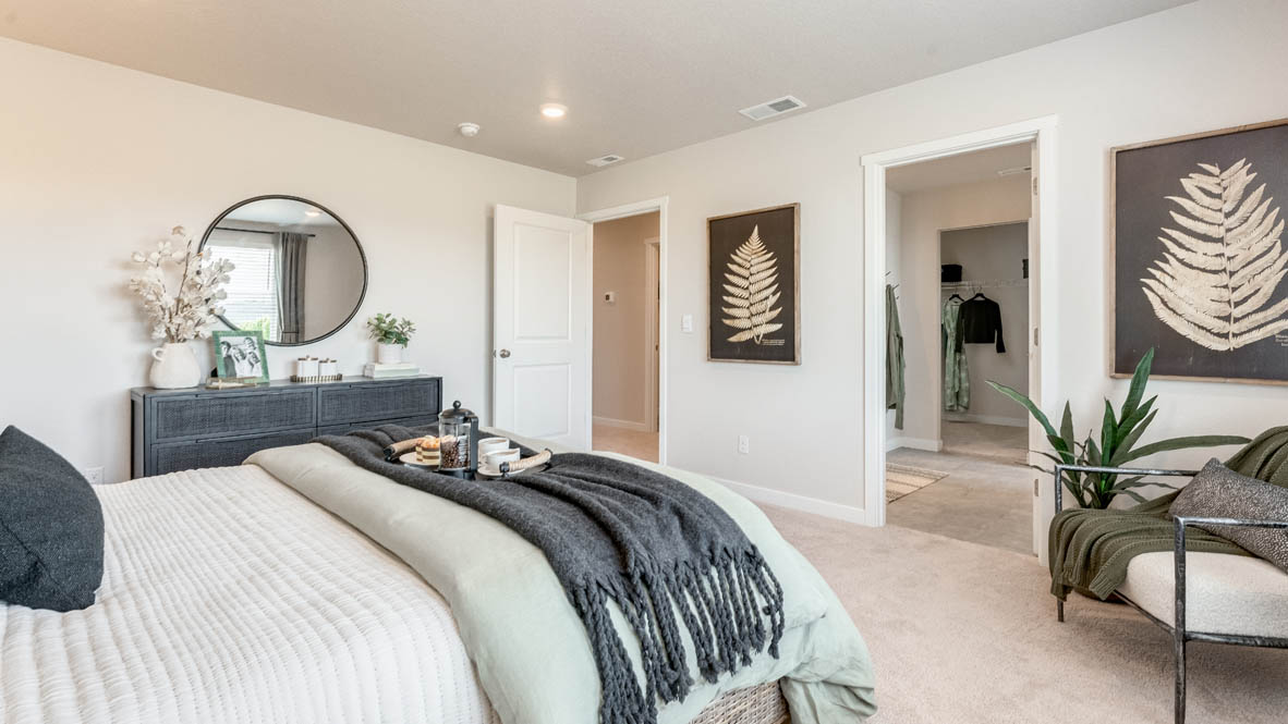 Davis Estates Primary bedroom with white carpet, painting, two lamps, a chair, dresser with a mirror, and the en suite bathroom in the background
