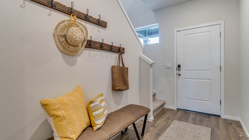 Marcola Meadows entry with coat hanging hooks, a low cushioned bench with pillows, and an entry rug