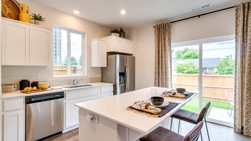 Marcola Meadows kitchen with white shaker style cabinets, stainless steel appliances, white quartz countertops, a kitchen island with two high seated stools, a pantry, and kitchen decor