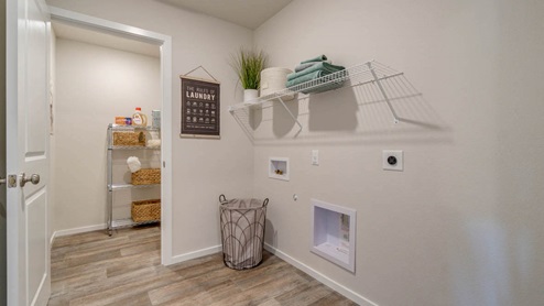 Marcola Meadows laundry room with white wire shelving, a storage cart, and a laundry hamper with laminate flooring