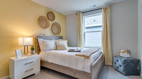 Marcola Meadows bedroom with yellow accent wall, full size bed, and white better