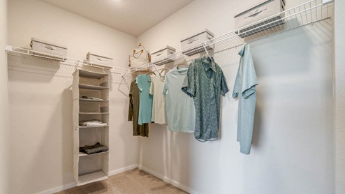 Marcola Meadows walk in closet with white wire shelving and hanging clothing