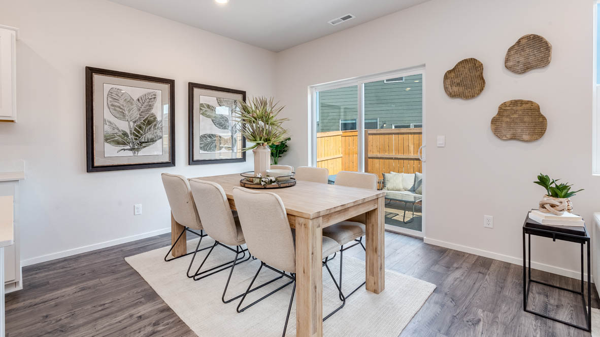 Marcola Meadows Dining room with rug, table with four chairs, two decorative paintings, three hanging decorations, sliding glass door
