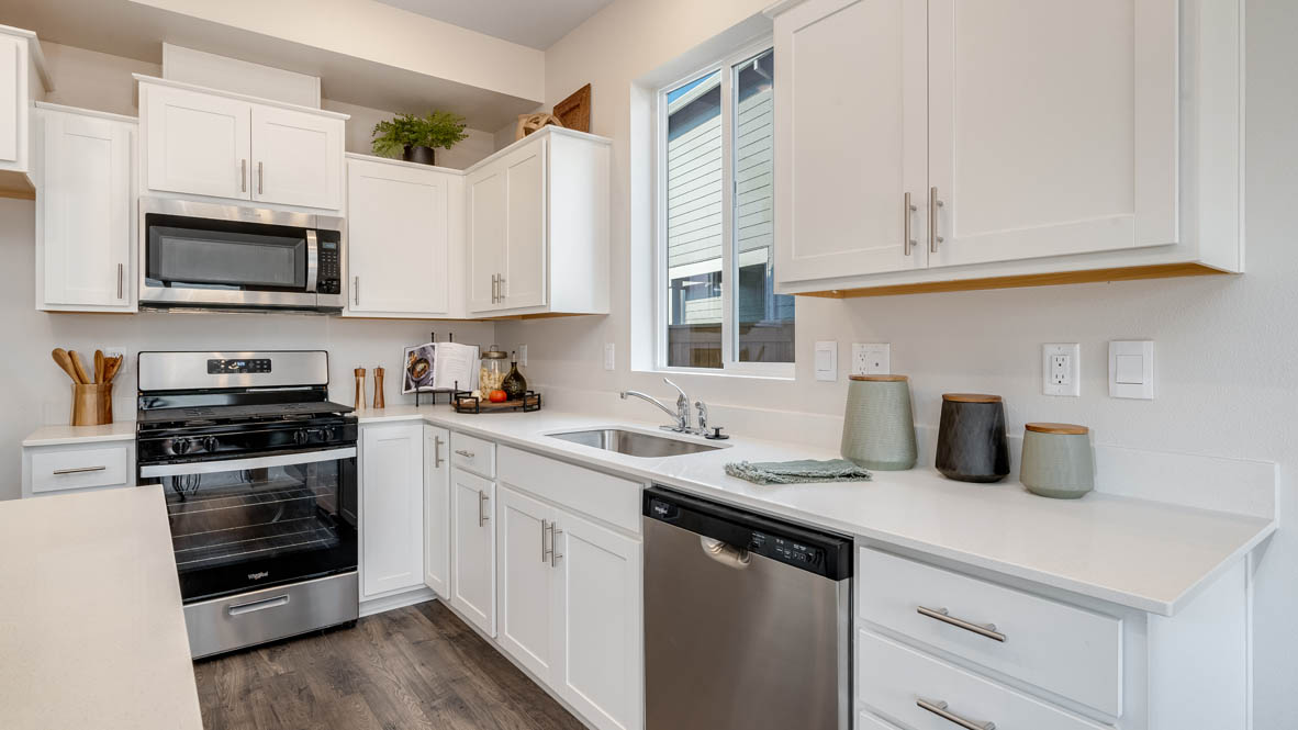 Marcola meadows kitchen with island with a breakfast bar, white quartz countertops, flooring, stainless steel appliances