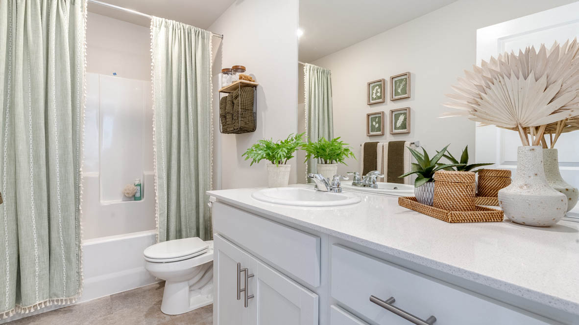 Marcola Meadows secondary bathroom with quartz countertops, white cabinets, mirror, shower tub, and mirror