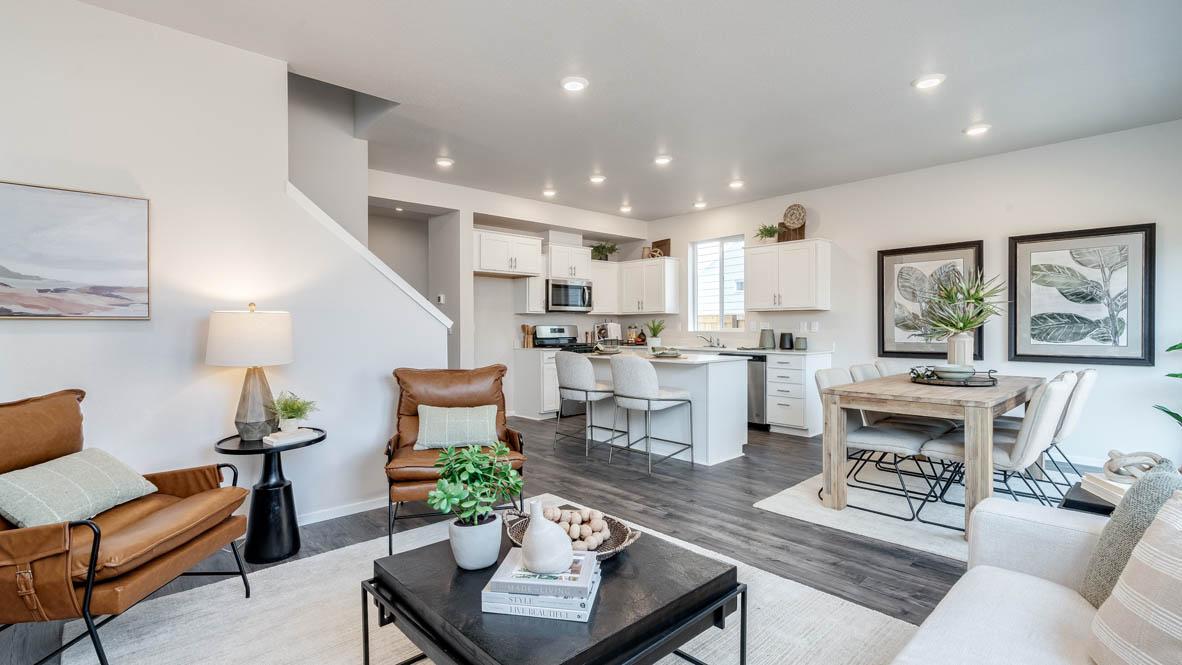 Marcola Meadows great room with carpet, coffee table, white couch with pillows, orange chair, entertainment center with tv, painting, and a lamp