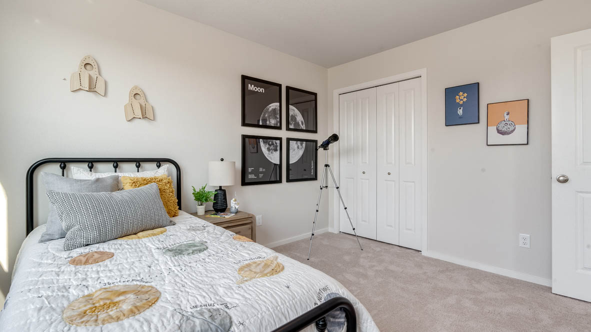 Marcola Meadows bedroom with bed, nightstand, telescope, pictures of a moon, a dresser, and a closet