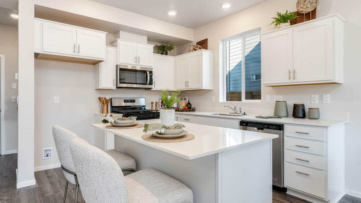 Marcola meadows kitchen with island with a breakfast bar, white quartz countertops, flooring, stainless steel appliances