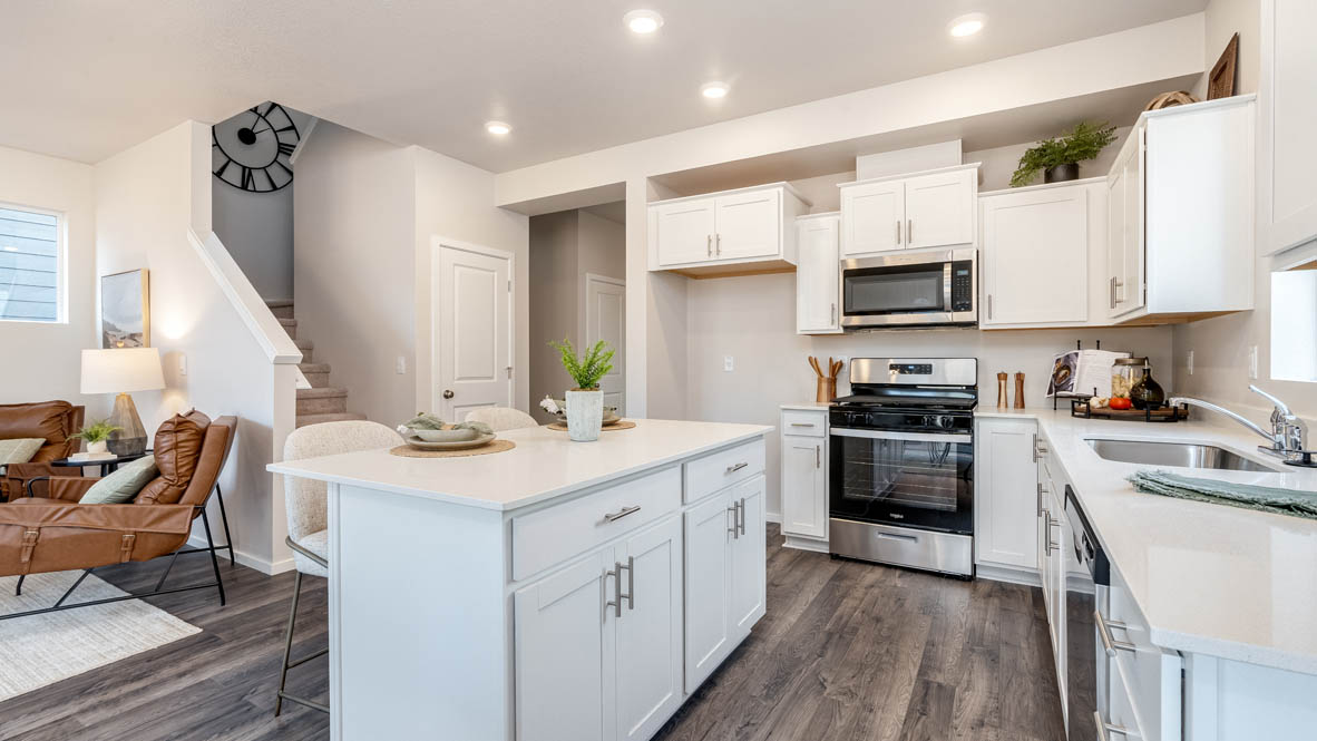 Marcola meadows kitchen with island with a breakfast bar, white quartz countertops, flooring, stainless steel appliances
