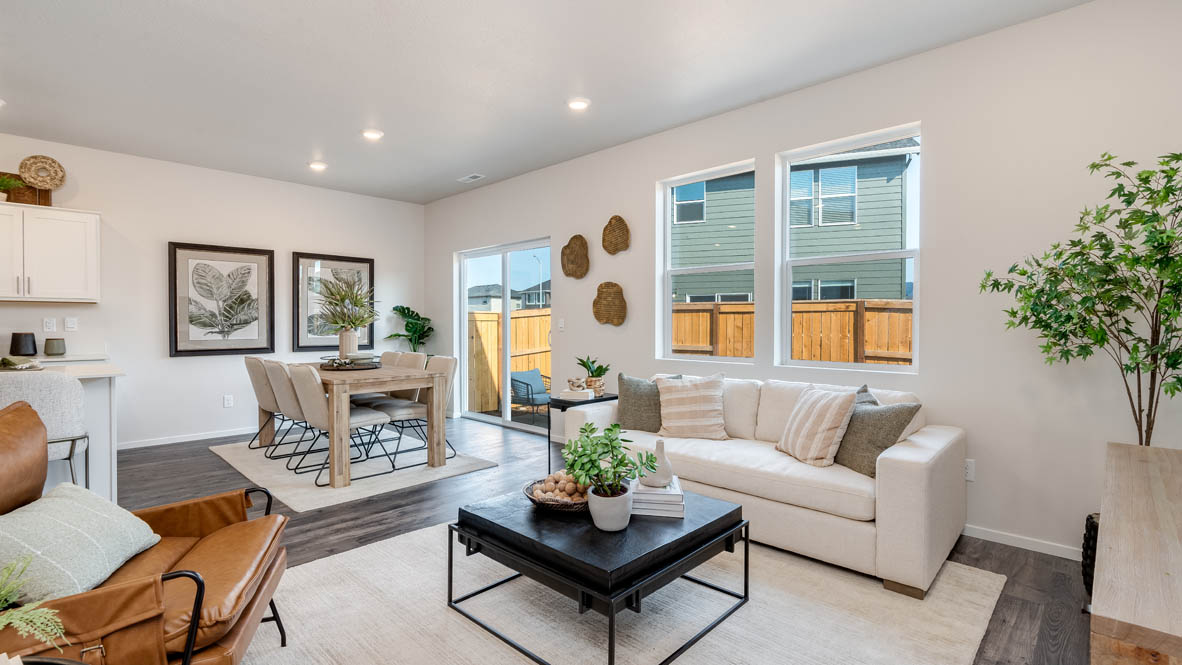 Marcola Meadows great room with carpet, coffee table, white couch with pillows, orange chair, windows, and a lamp