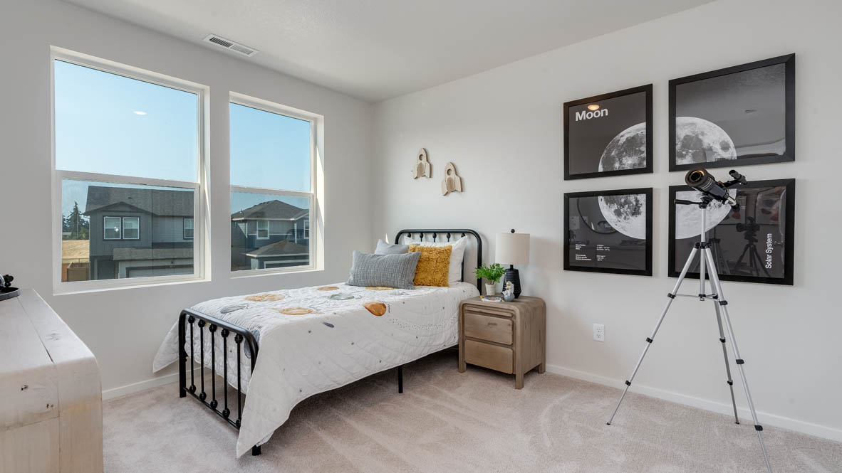 Marcola Meadows bedroom with bed, nightstand, telescope, pictures of a moon, a dresser, and a window