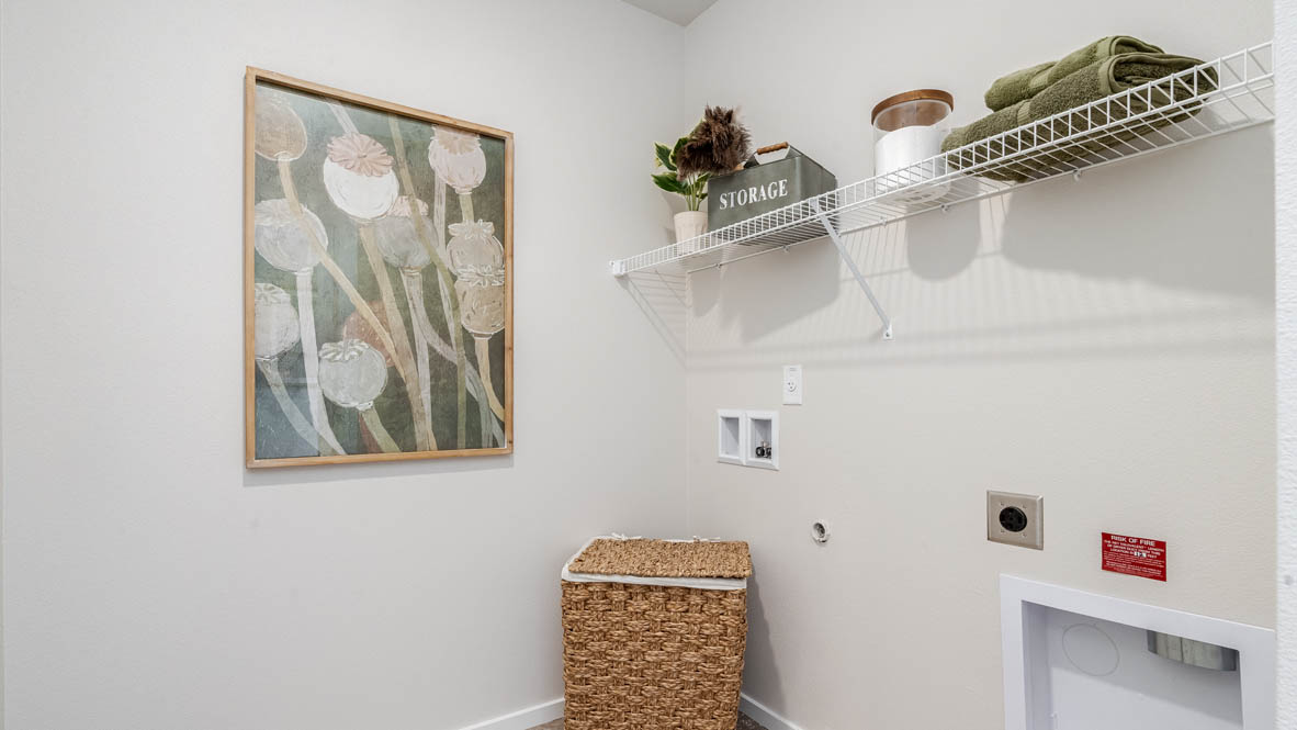 Marcola Meadows laundry room with painting, white wire shelving, and hamper