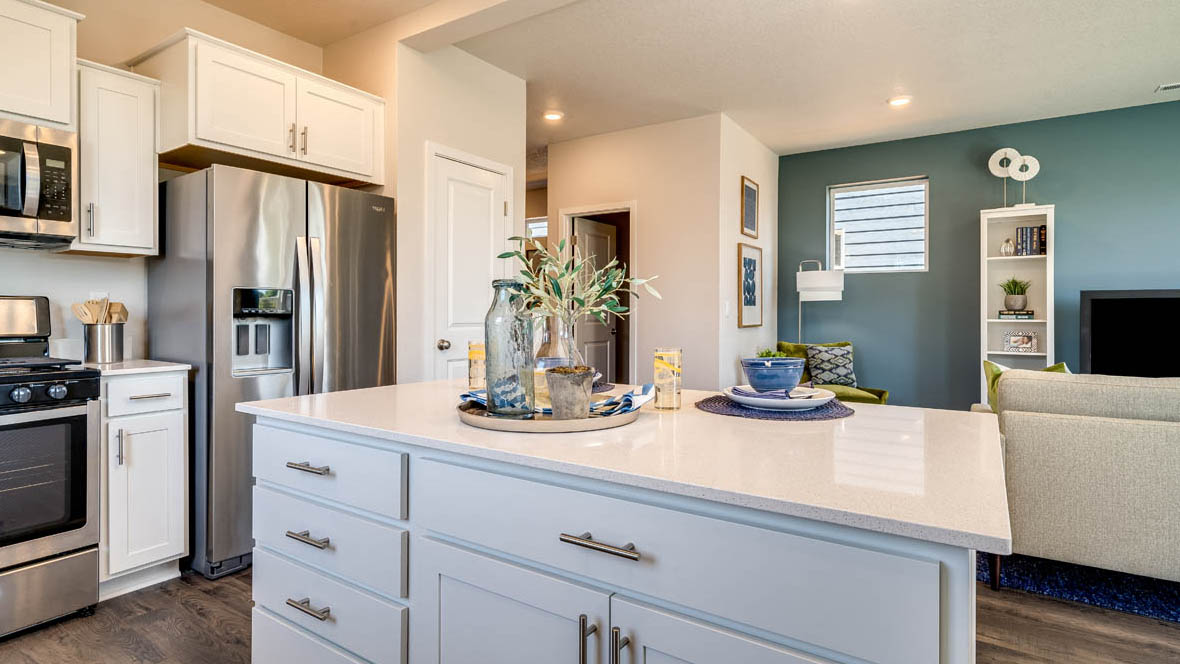 Marcola Meadows Kitchen with white cabinets, an island, stainless steel fridge and dishwasher