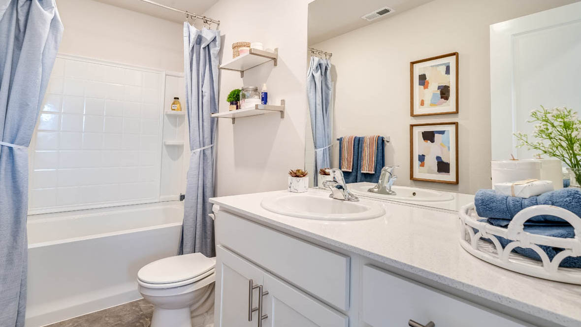 Marcola Meadows Bathroom that includes a single sink vanity with white cabinet and countertops, a toilet, and a shower tub