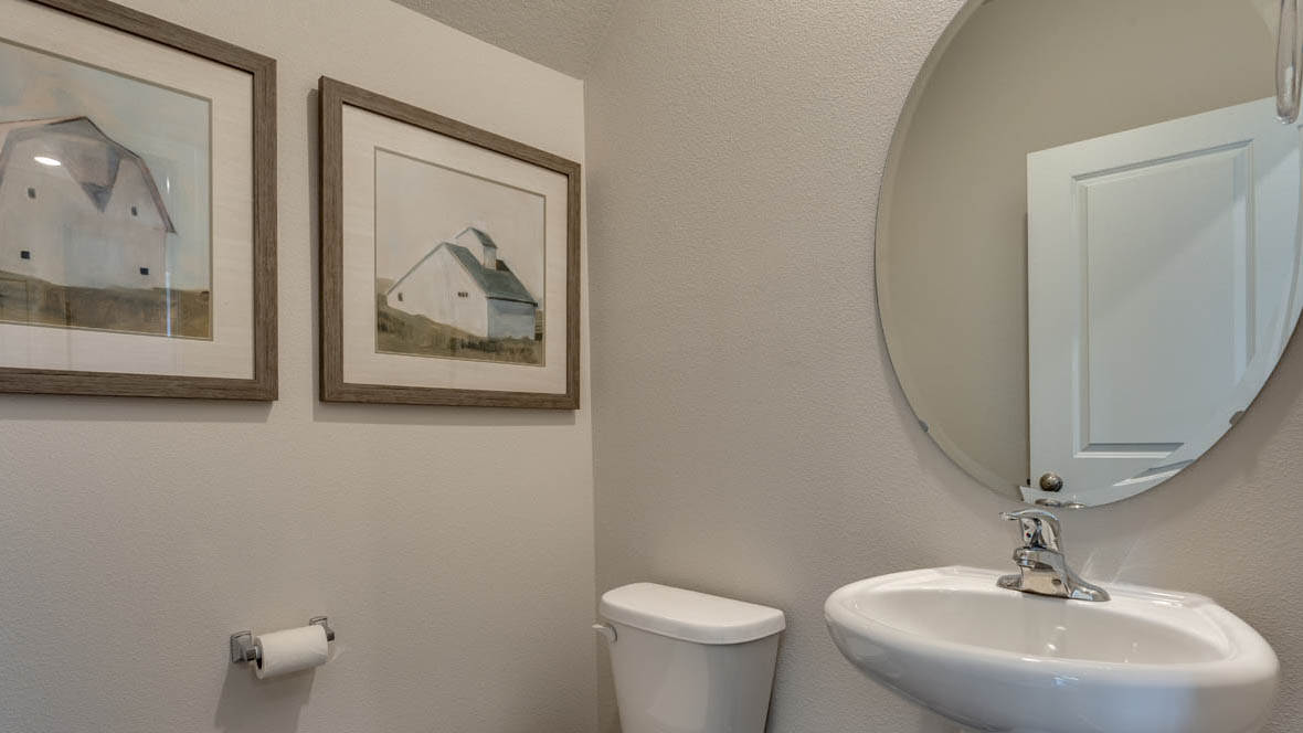 Marcola Meadows Powder room with a white toilet, single sink and circle mirror
