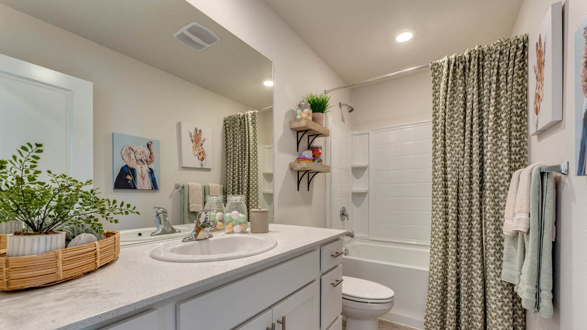 Marcola Meadows Bathroom that includes a single sink vanity with white cabinet and countertops, a toilet, and a shower tub