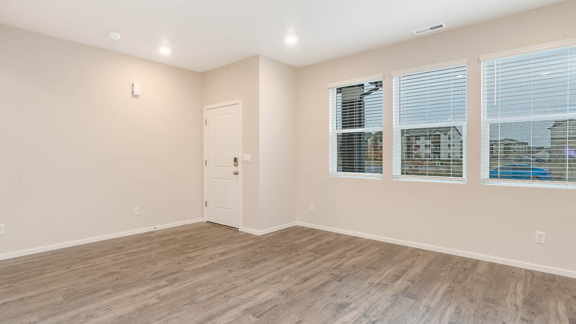 Marcola Meadows Great Room with white walls, laminate flooring, front door, and windows