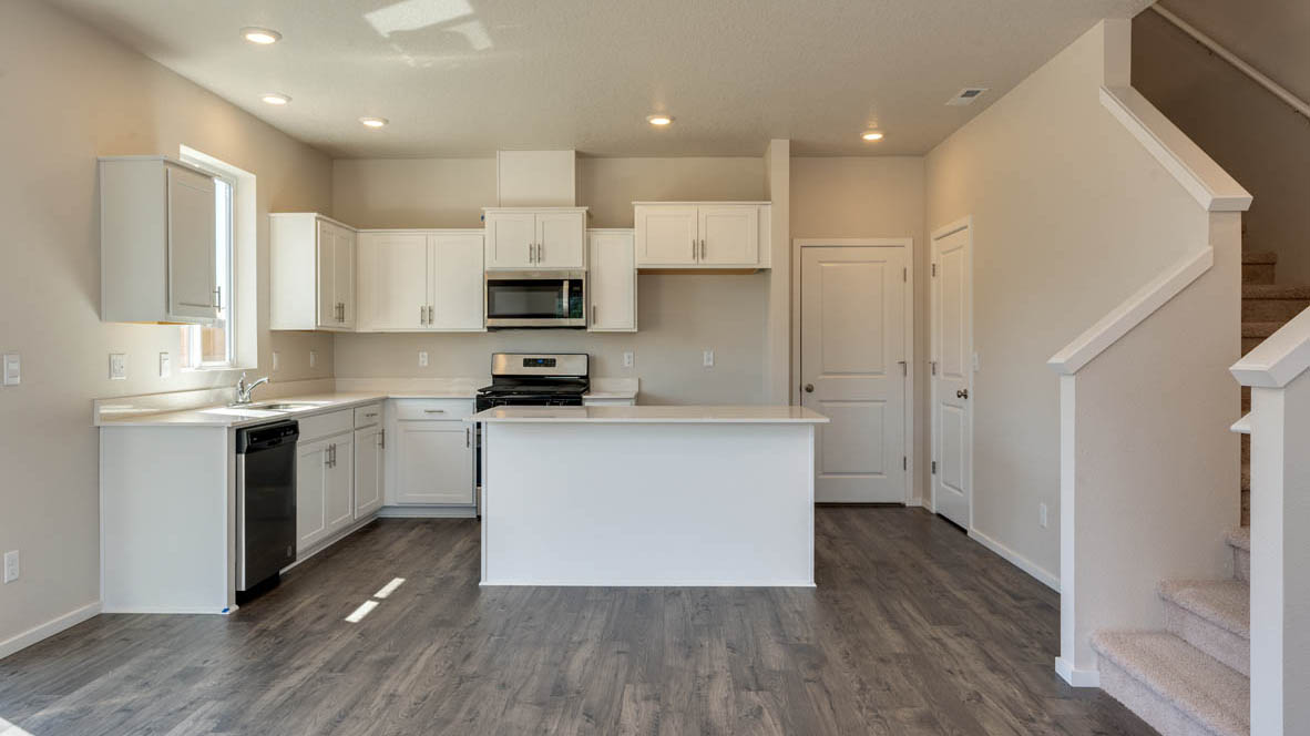 Marcola Meadows Kitchen with white quartz countertops, white cabinets, an island and stainless steel appliances