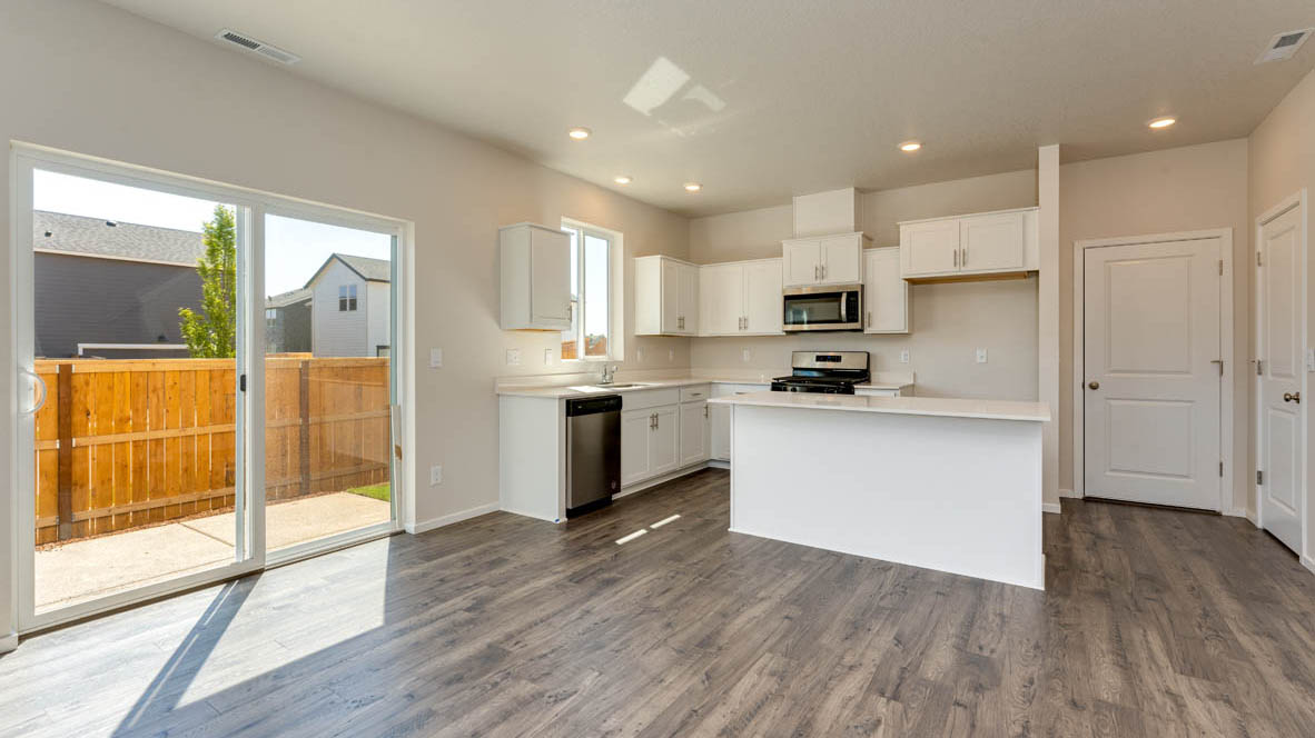 Marcola Meadows Kitchen with white quartz countertops, white cabinets, an island and stainless steel appliances