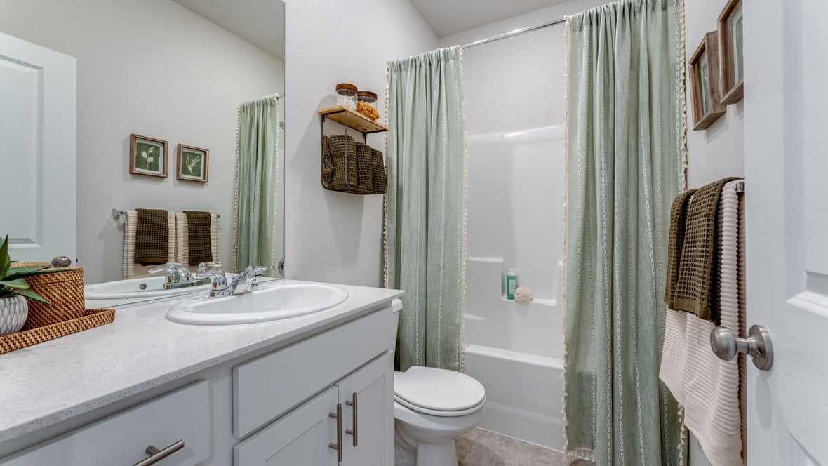 Marcola Meadows Bathroom that includes a single sink vanity with white cabinet and countertops, a toilet, and a shower tub