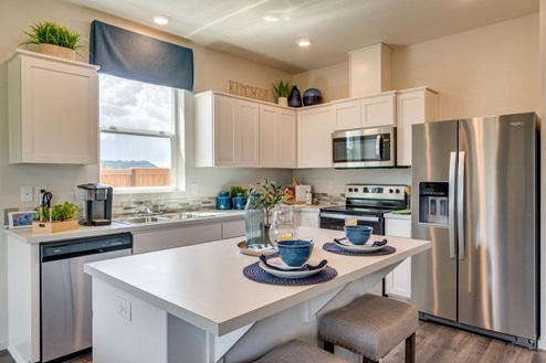 Marcola Meadows Kitchen with white cabinets, an island, stainless steel fridge and dishwasher