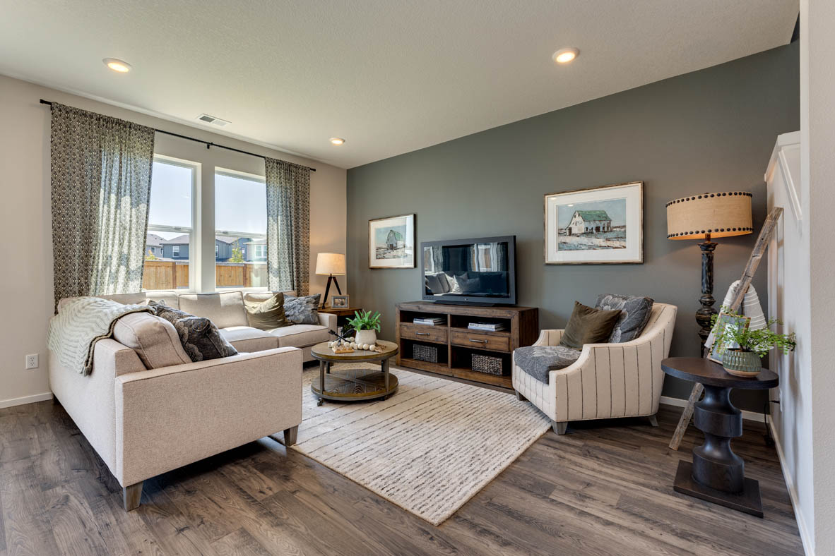 Marcola Meadows Great room with two windows, a white L-shaped couch, and a green accent wall
