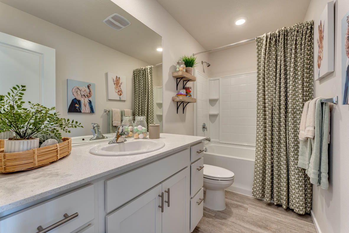 Marcola Meadows Bathroom that includes a single sink vanity with white cabinet and countertops, a toilet, and a shower tub