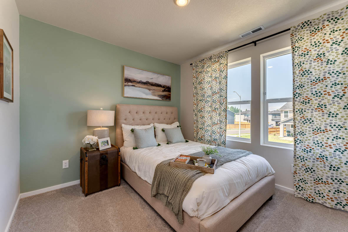 Marcola Meadows bedroom with green accent wall and two windows