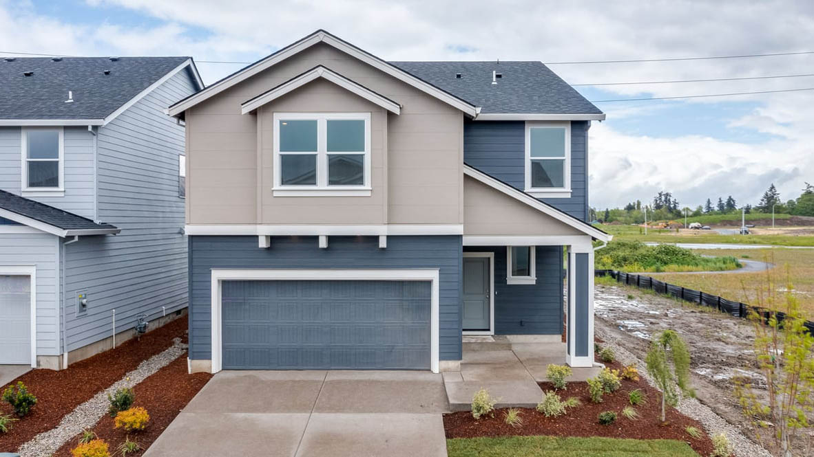 Marcola Meadows Two-story home with gray siding and a covered porch and two-car garage.