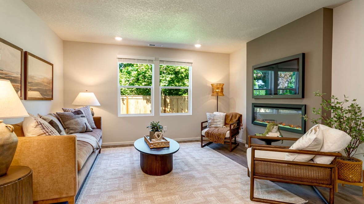 Eden Estates great room with fireplace, laminate flooring, and windows