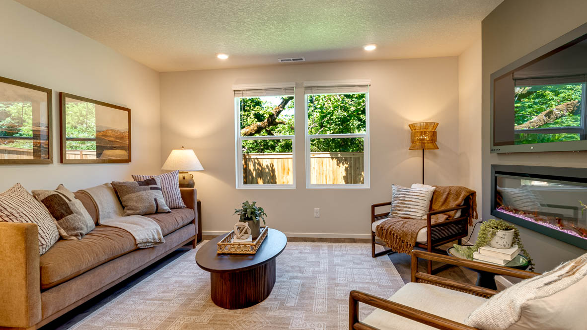 Eden Estates great room with fireplace, laminate flooring, and windows