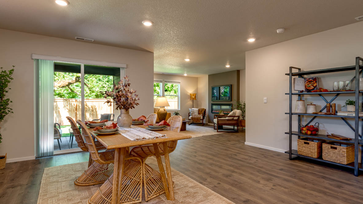 Eden Estates dining room with laminate flooring, windows, and the kitchen in the background