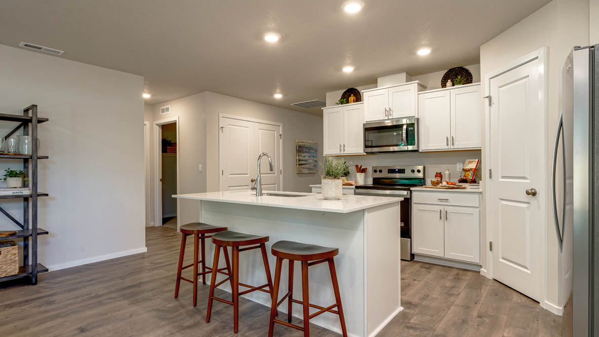 Eden Estates kitchen with laminate flooring, stainless steel appliances, cabinets, window, solid surface countertops