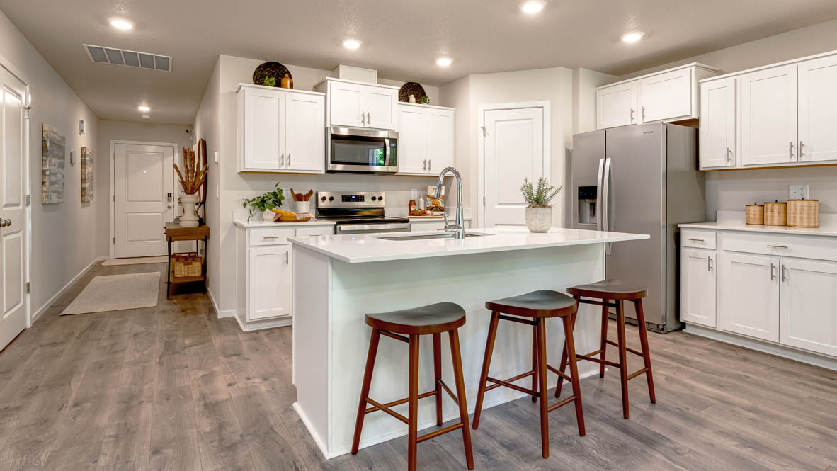 Eden Estates kitchen with laminate flooring, stainless steel appliances, cabinets, window, solid surface countertops