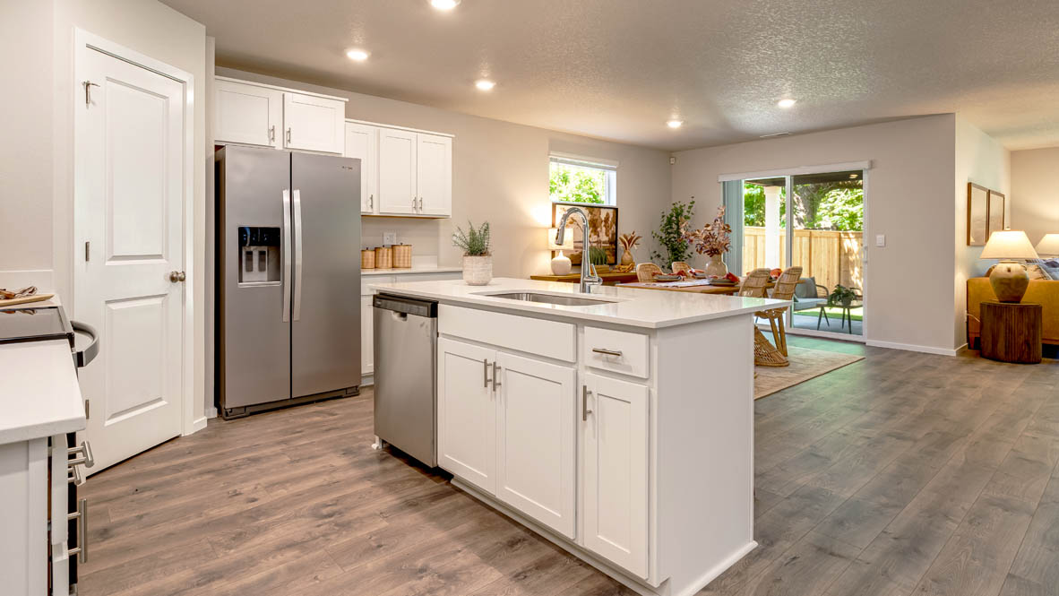 Eden Estates kitchen with laminate flooring, stainless steel appliances, cabinets, window, solid surface countertops