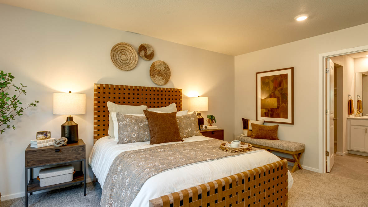 Eden Estates primary bedroom with 2 nightstands, a bed with white sheets and accent blanket,  closet