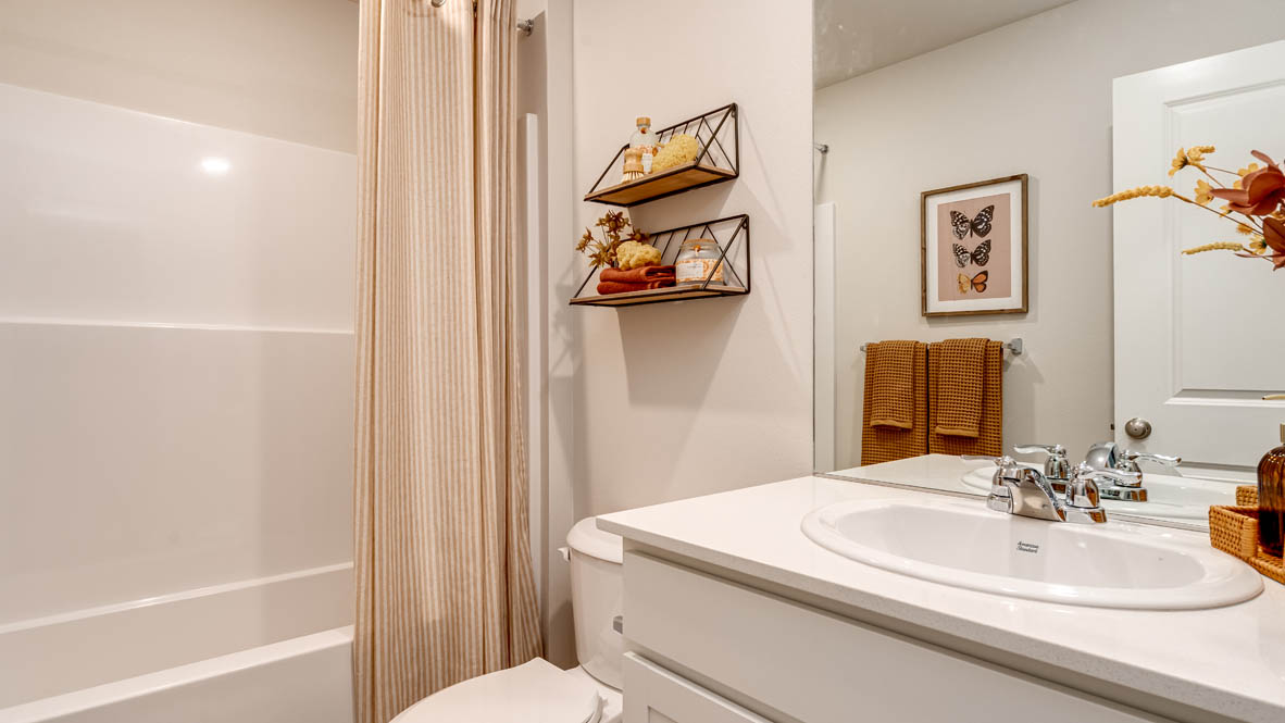 Eden Estates bathroom with toilet, and white shower tub