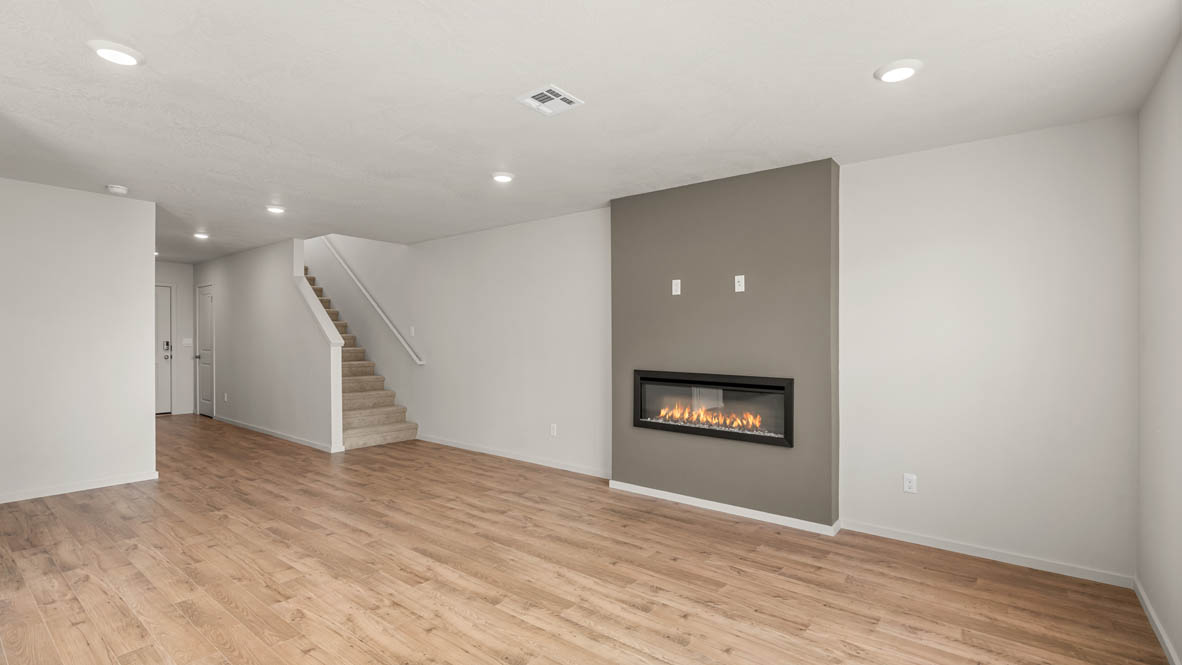Eden Estates great room with fireplace, laminate flooring, and windows