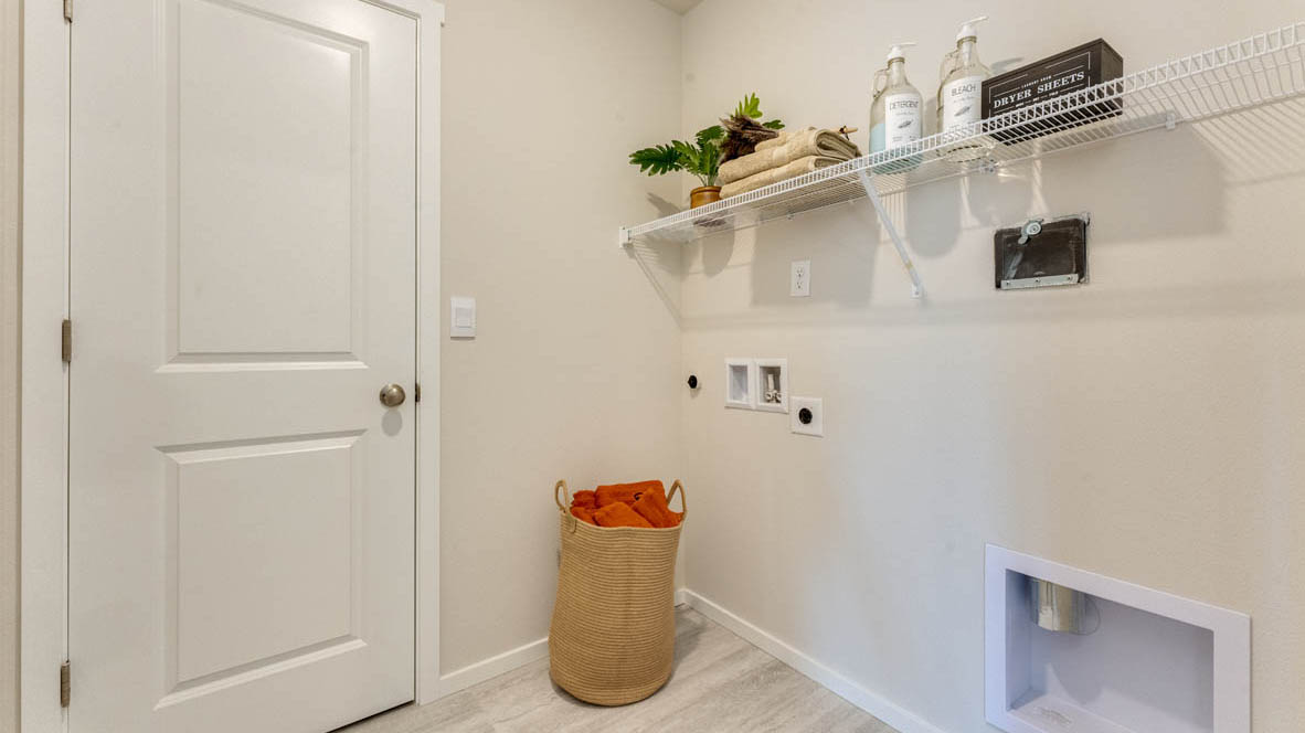 Eden Estates laundry room with white wire shelving, and a hamper