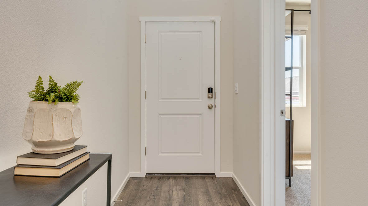 Eden Estates entry with view of front door, painting, stairs, powder room, and laminate flooring