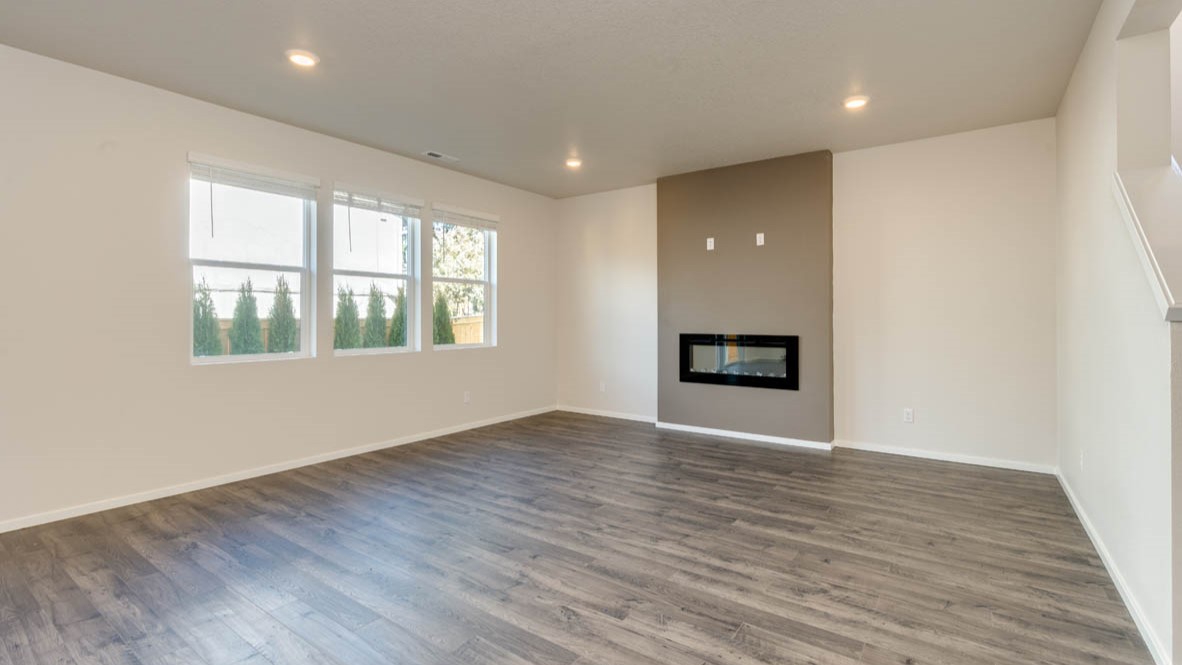 Eden Estates great room with fireplace, laminate flooring, and windows